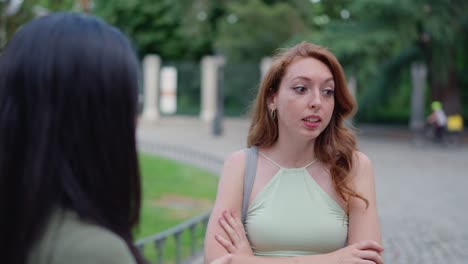 young woman with red hair reacting during an outdoor conversation