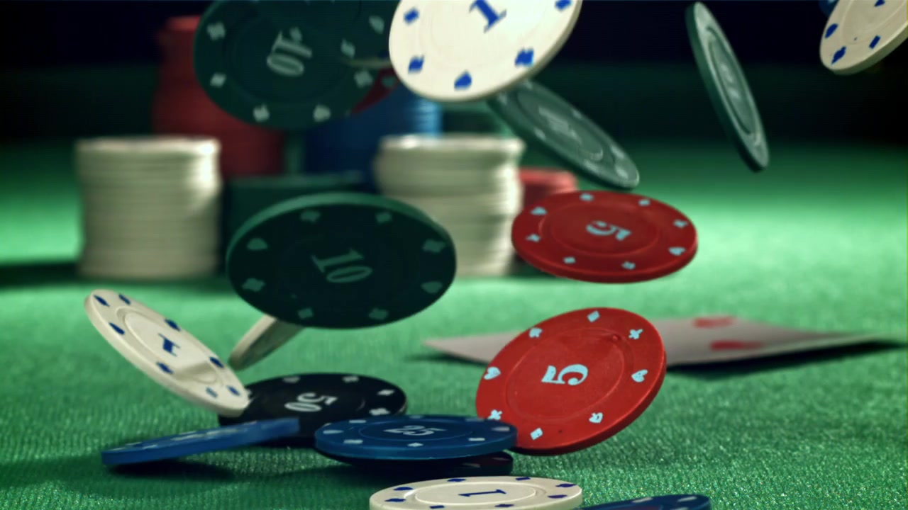 Fiches da poker colorate che cadono e si disperdono su un tavolo di feltro verde
