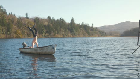 A-young-man-hand-standing-on-a-boat-by-a-scenic-lake-view