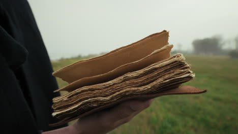 book with holy scriptures read by a man in a foggy winter park