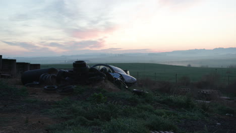 sunset over a spanish scrapyard old broken down car and piles of tires