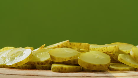 sliced dill pickles on a wooden cutting board