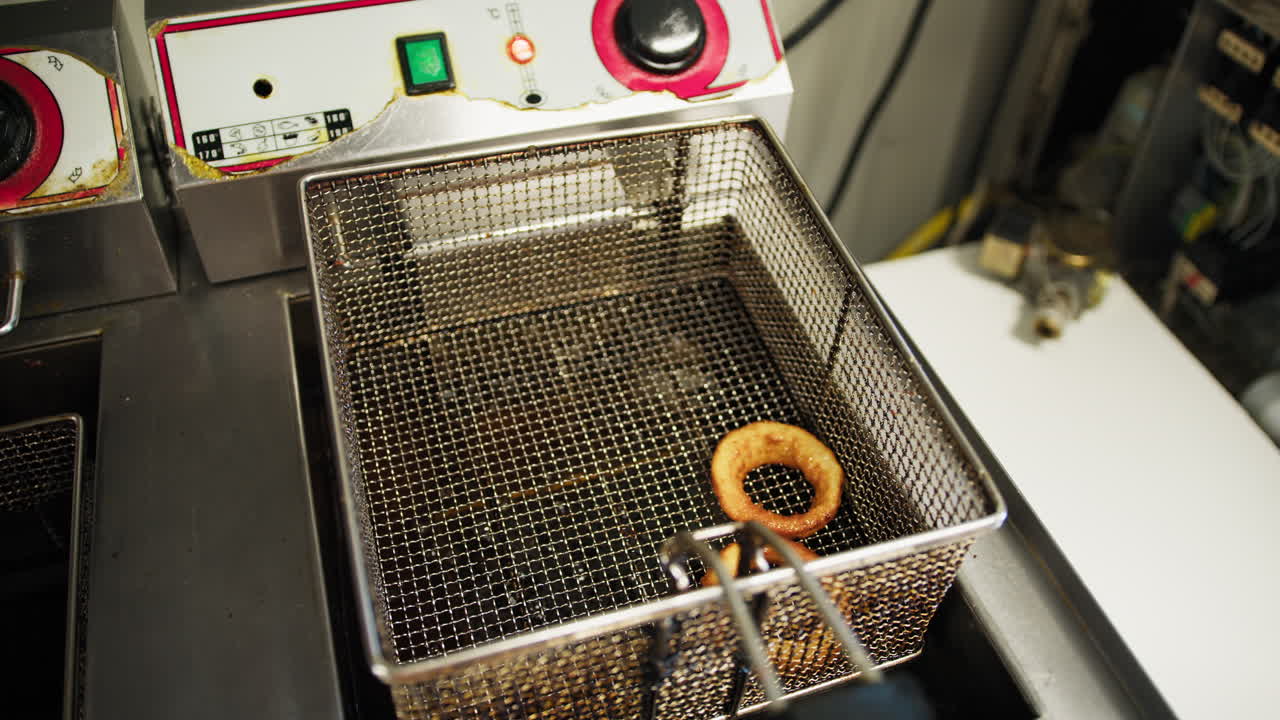 Chef Putting The Onion Rings Out Of The Frying Oil