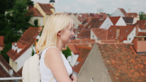 a young woman tourist is admiring the old european city from a height 2