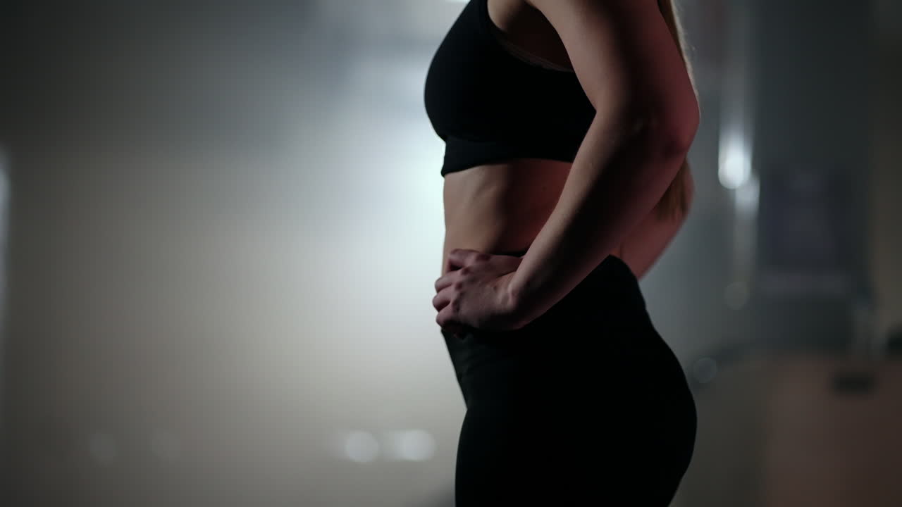 Slow motion: A tired woman recovers strength in training after an endurance exercise. Achieve success and move forward through obstacles. The concept of a strong woman