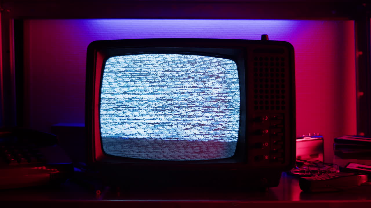 A retro TV displaying static noise, creating a nostalgic vintage atmosphere with blue and green hues.