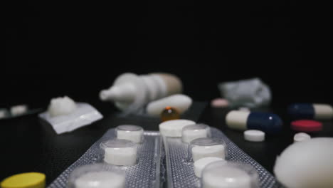 drugs and medicines with latex gloves on dark background