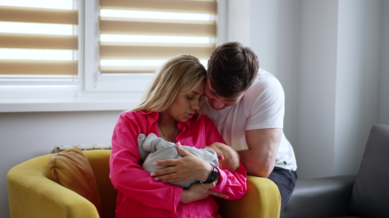 Loving new-made parents with their child. Couple swaying their baby in maternity hospital ward.
