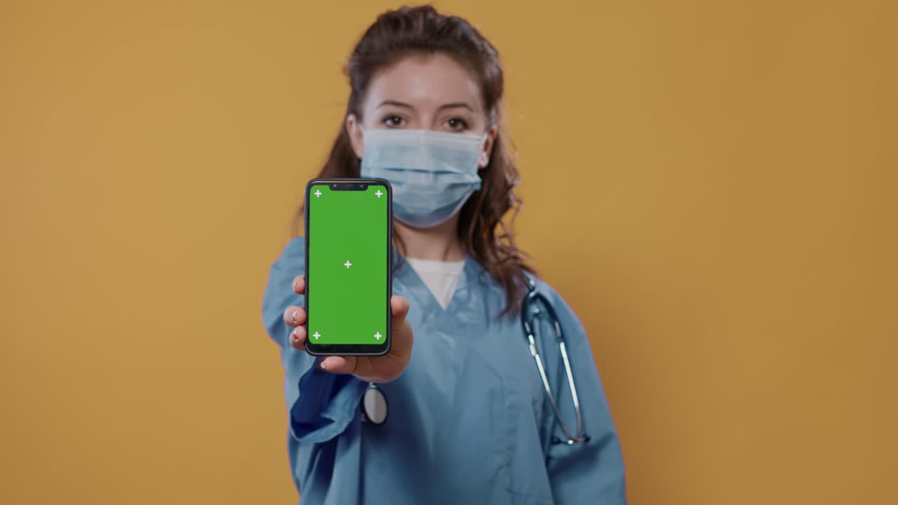 Nurse with Face Mask Showing Phone with Green Screen