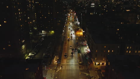 Forwards-fly-above-illuminated-street-in-night-metropolis.-Vehicles-driving-against.-Manhattan,-New-York-City,-USA