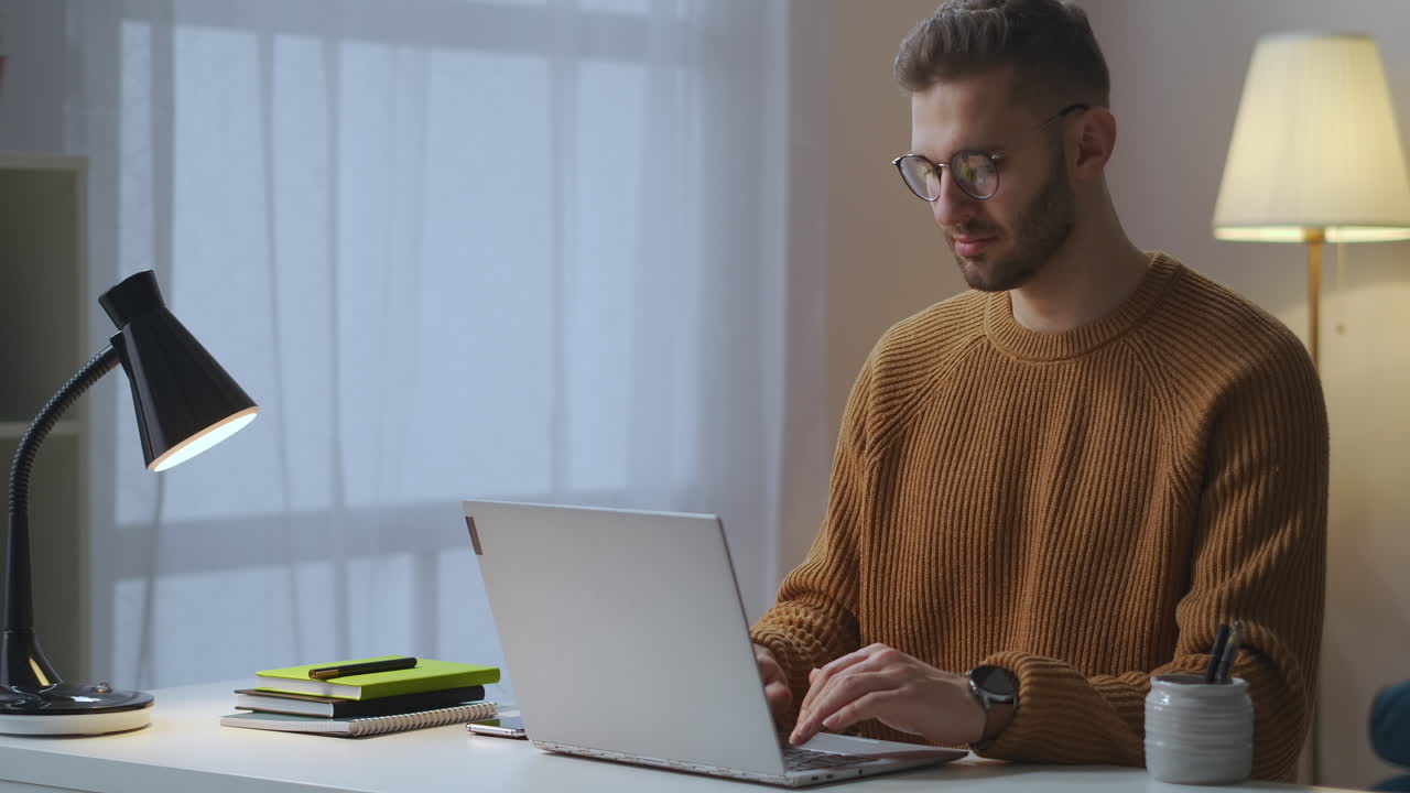 hombre adulto está escribiendo y enviando mensajes por internet usando una computadora portátil sentado en la sala de estar usando redes sociales y correo electrónico retrato de hombre guapo en el interior