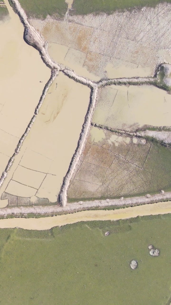 Aerial: Severe drought affecting dry agricultural land with irrigation channels - top down shot.