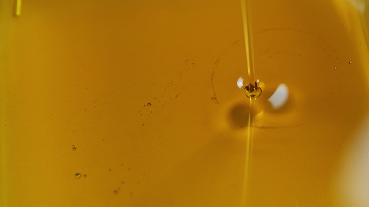 наливание масла автомобильного двигателя или оливкового овоща приготовление пищи и пузырь изолированный. наливание меда. медленное движение