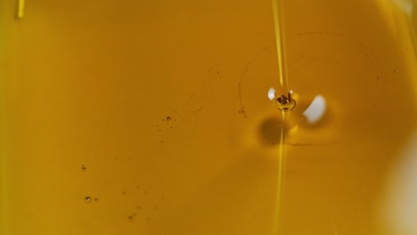 verter aceite en el motor del coche o oliva cocción de verduras y burbujas aisladas. verter miel. cámara lenta
