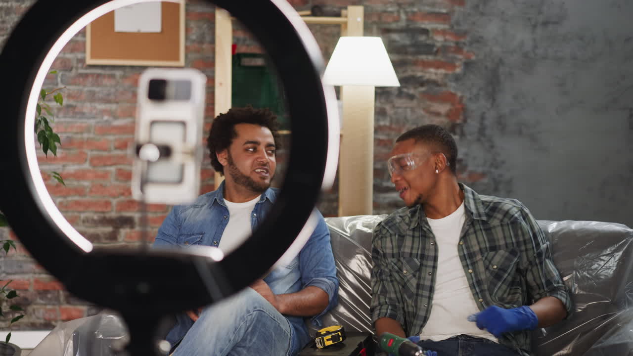 Joyful black guys handymen talk to followers shooting vlog
