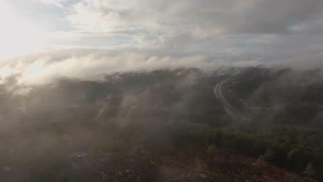 Drohnenaufnahmen-Eines-Funkturms-Und-Einer-Wohnsiedlung-In-Norwegen-Mit-Etwas-Nebel-In-Der-Luft-Und-Sonne,-Die-Die-Wolken-Erhellt