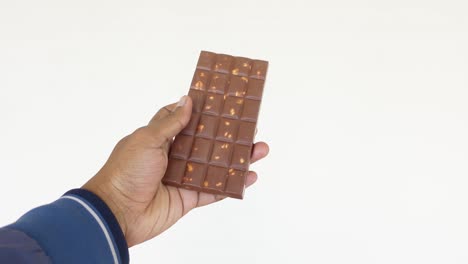 a hand holding a chocolate bar