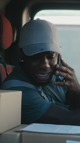 delivery driver making a phone call in his truck
