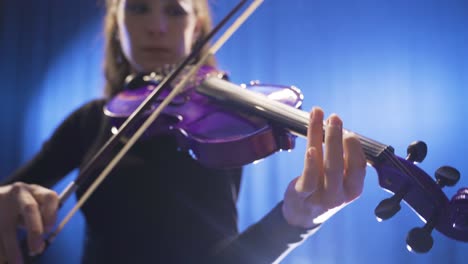 Close-up-of-musician-playing-violin-on-stage.