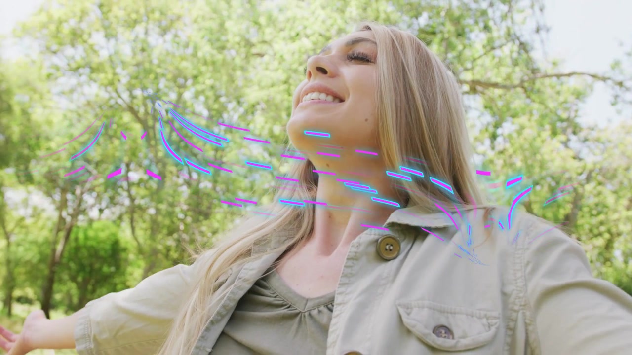 Donna che apre le braccia in un parco boscoso, la telecamera si allontana, con scie di flusso che visualizzano il vento per il design.