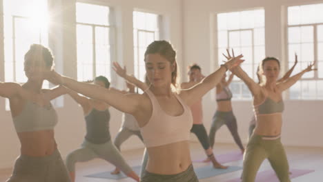 Clase-De-Yoga-Mujeres-Multiétnicas-Practicando-Pose-Guerrera-Disfrutando-De-Un-Estilo-De-Vida-Saludable-Haciendo-Ejercicio-En-El-Gimnasio-Al-Amanecer