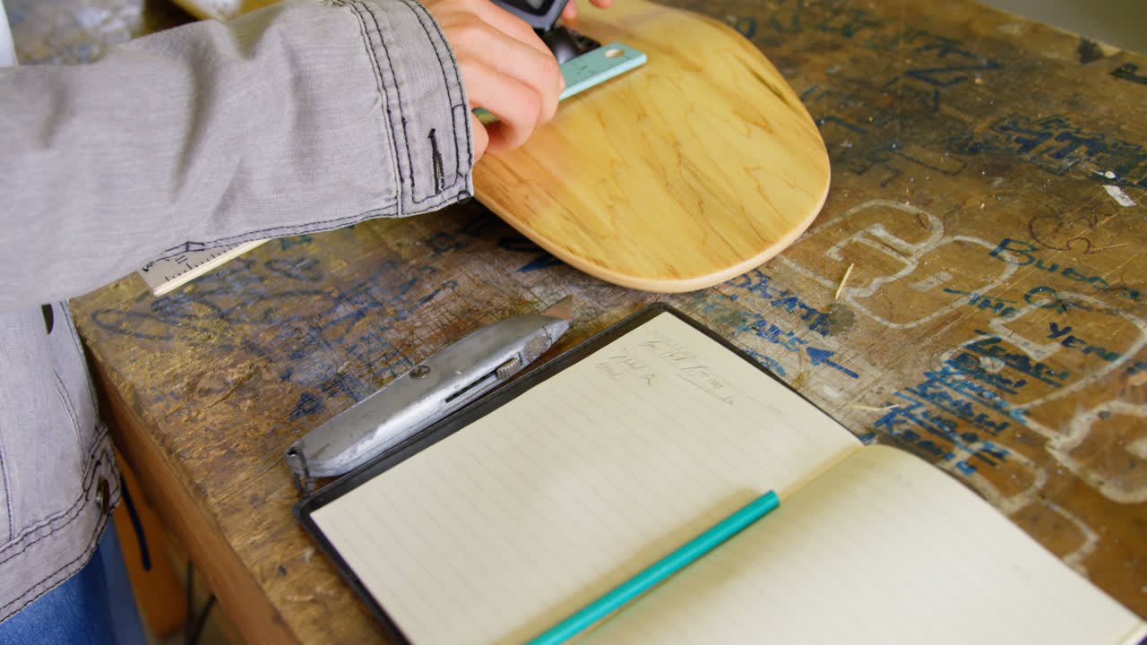 молодая женщина ремонтирует скейтборд грузовик на ее скейтборд в мастерской 4k