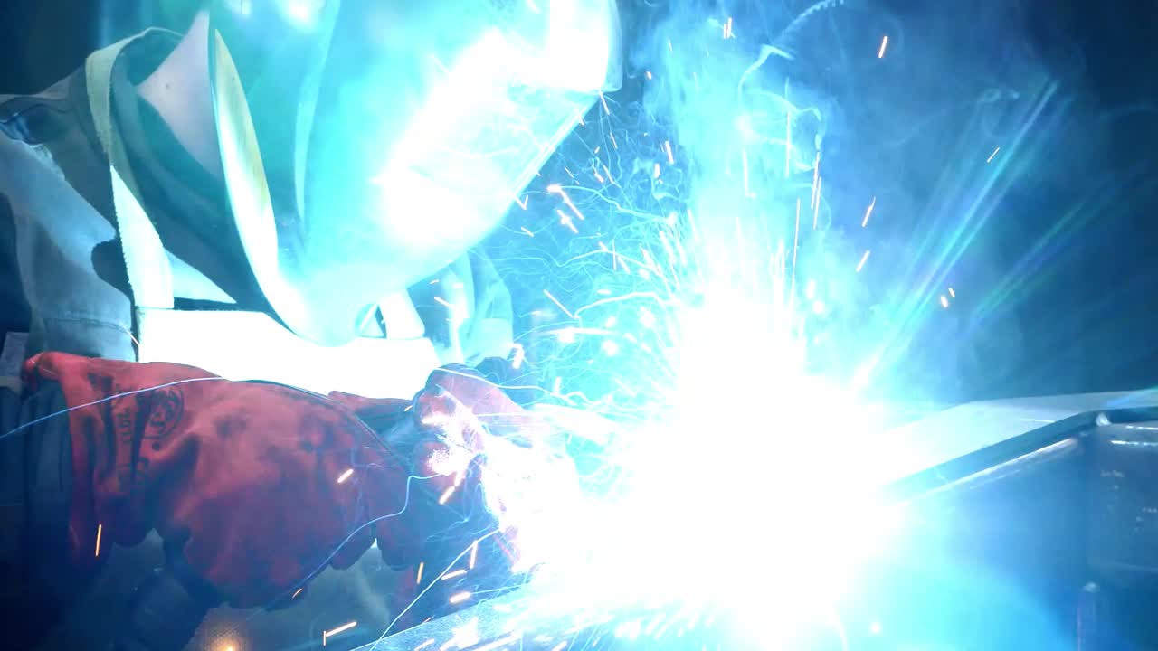 Welder working with electrode at semi-automatic arc welding