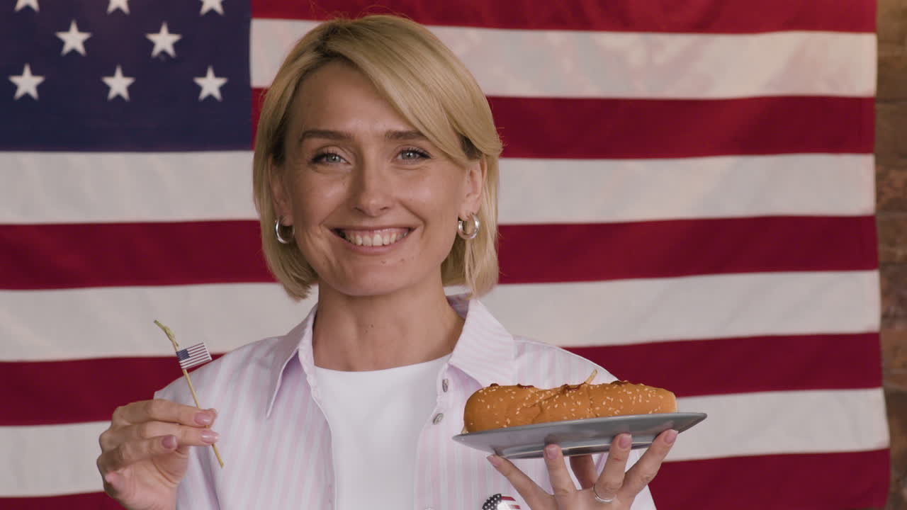 Woman enjoying a hot dog with American flag