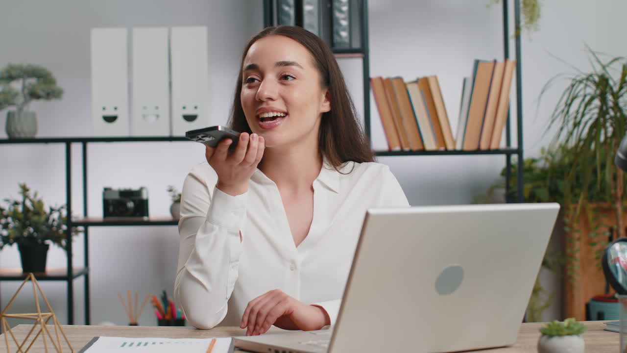 Giovane donna d'affari che lavora parla al cellulare in ufficio usando applicazioni di chat messenger