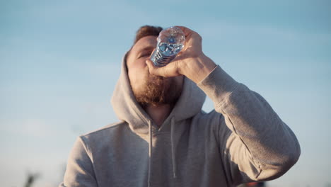 hombre bebiendo agua al aire libre