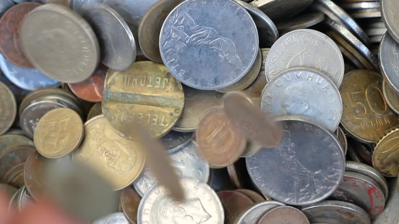 Various Old Coins Falling into a Large Pile
