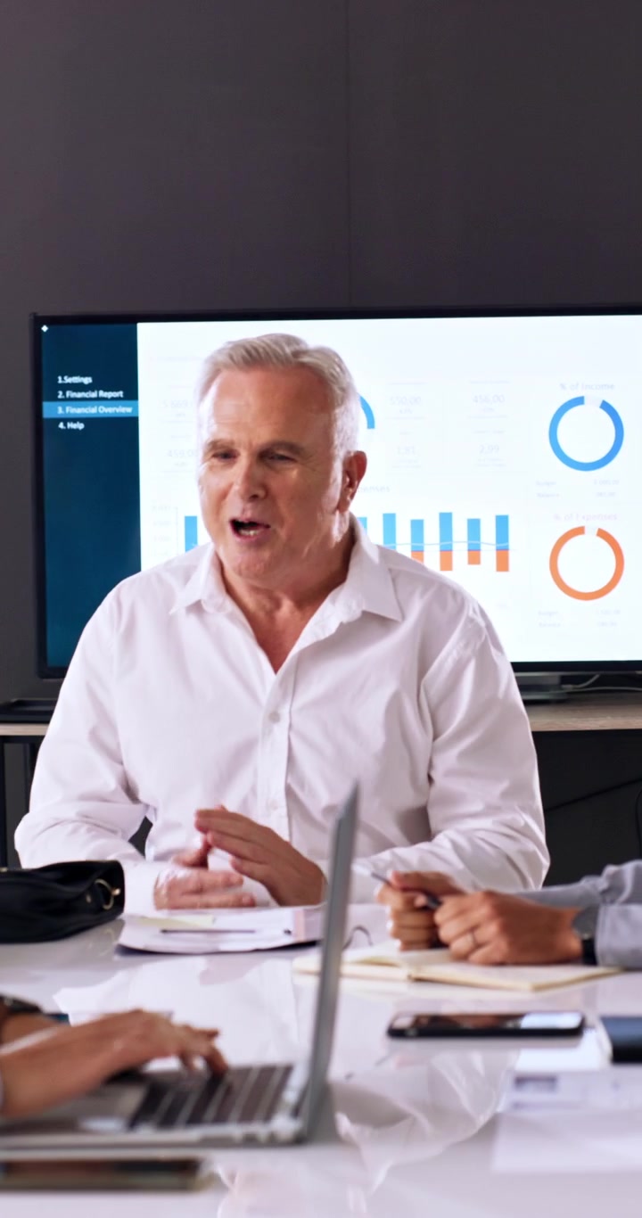 Mature Businessman Sitting Down for a Meeting in a Modern Office