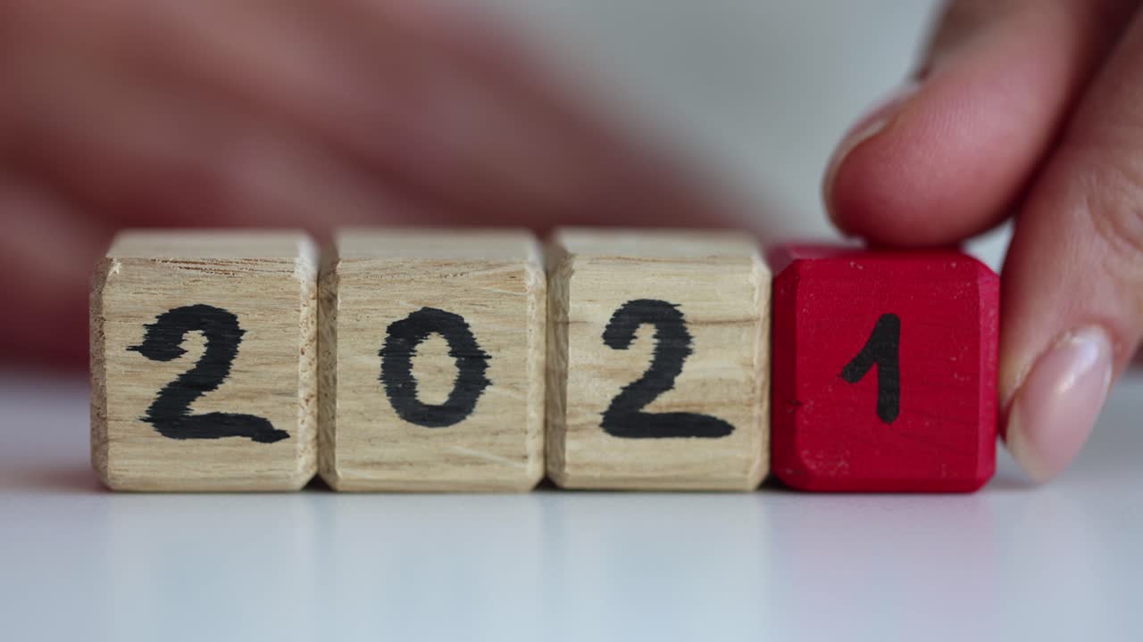 Mano di donna che cambia la data fatta di cubi di legno dal 2021 al 2022 in primo piano, filmato in 4k al rallentatore