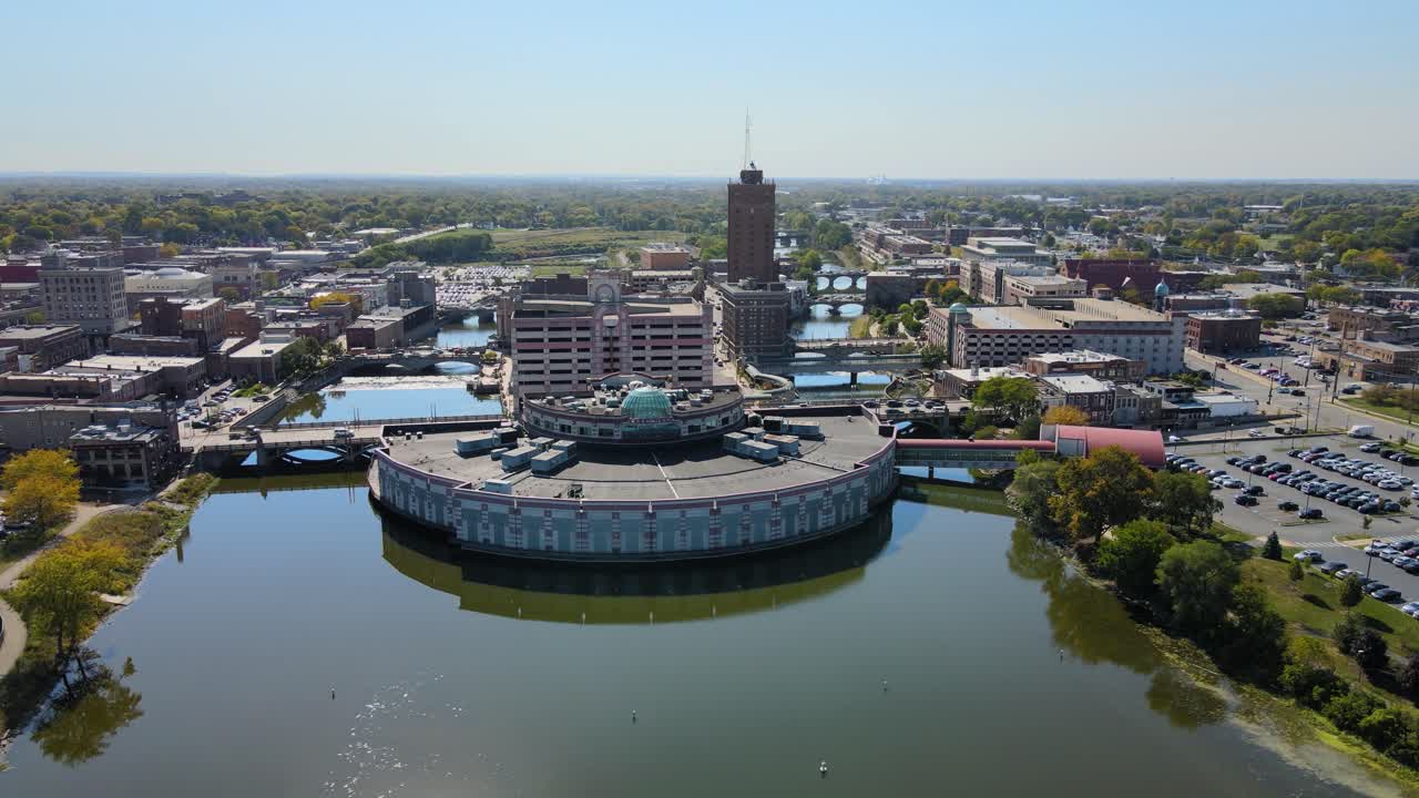 Drone footage capturing downtown Aurora, IL, a Chicago suburb in the Chicagoland area, near the river, buildings, and the Metra train line. Orbit Left Day S