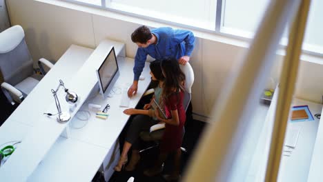 Executives-discussing-over-computer-at-desk