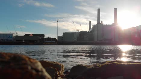 shore of thames river reflecting battersea power station london