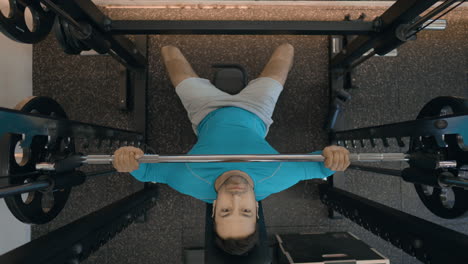 Top-View-Of-A-Person-Doing-Seated-Barbell-Shoulder-Press-Inside-The-Gym