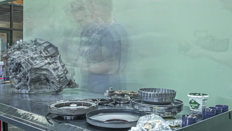 Static-shot-of-workers-constructing-a-new-gearbox-in-timelapse-in-a-chamber-inside-a-factory