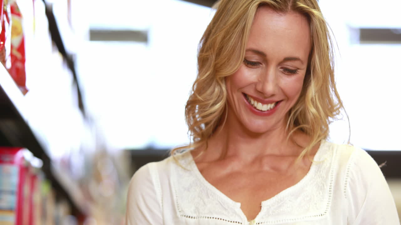 madre sonriente comprobando la lista de compras