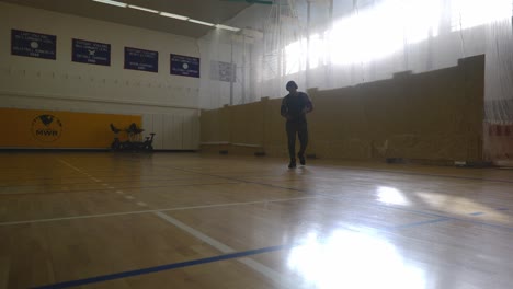 male walking from wall crossing himself - strong athletic muscular black man standing on basketball court looking around in 4k