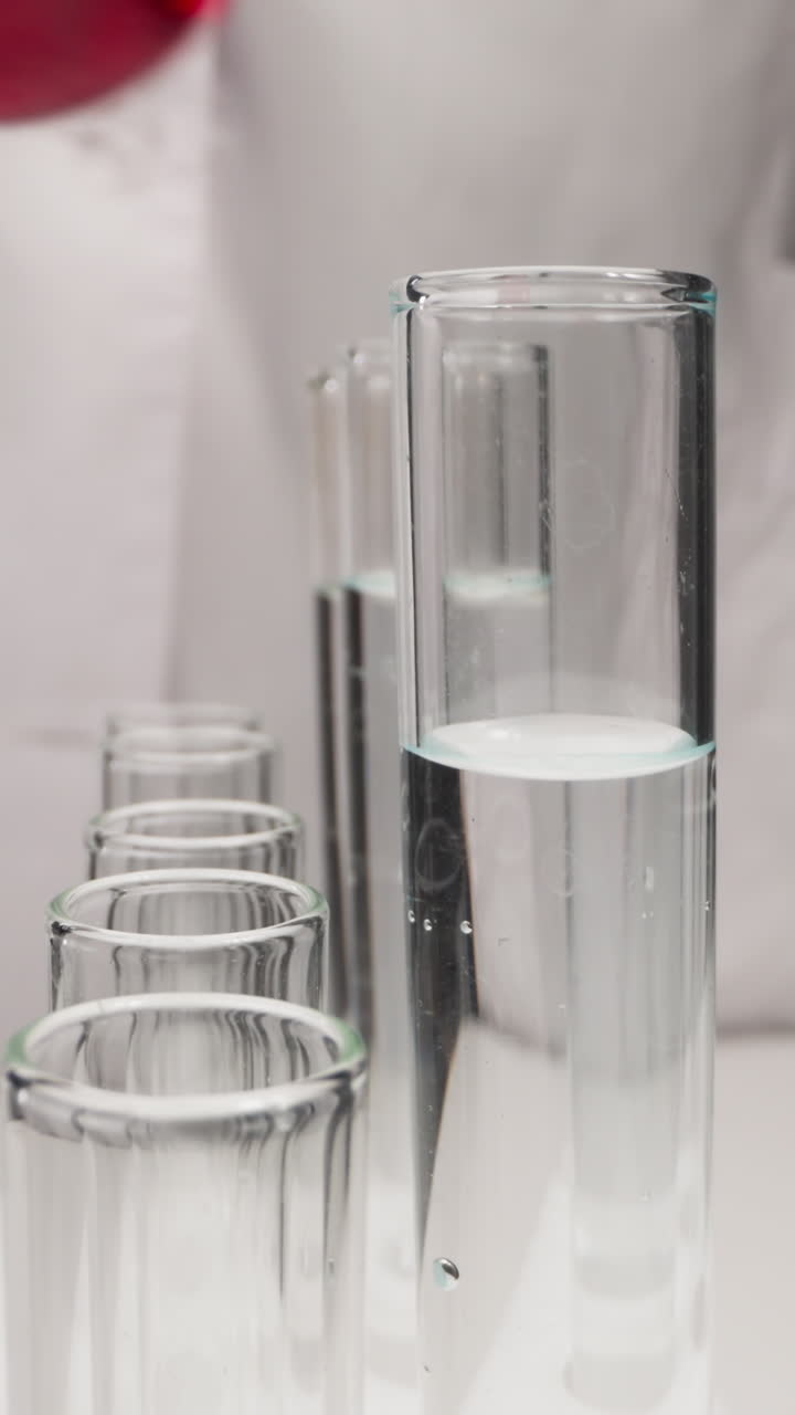 Student in white robe replaces test tubes on rack in laboratory slow motion. Probe lens shot of chemical researching work extreme closeup