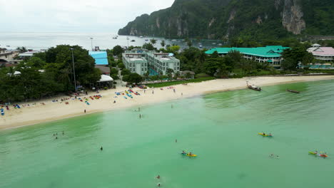 La-Pintoresca-Isla-De-Aguas-Turquesas-De-La-Isla-Koh-Phi-Phi-Con-Turistas-Disfrutando-De-Deportes-Acuáticos.