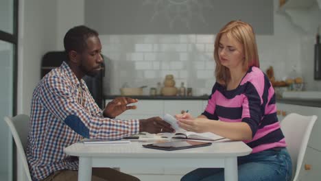 stressed multiethnic couple reviewing bank invoices