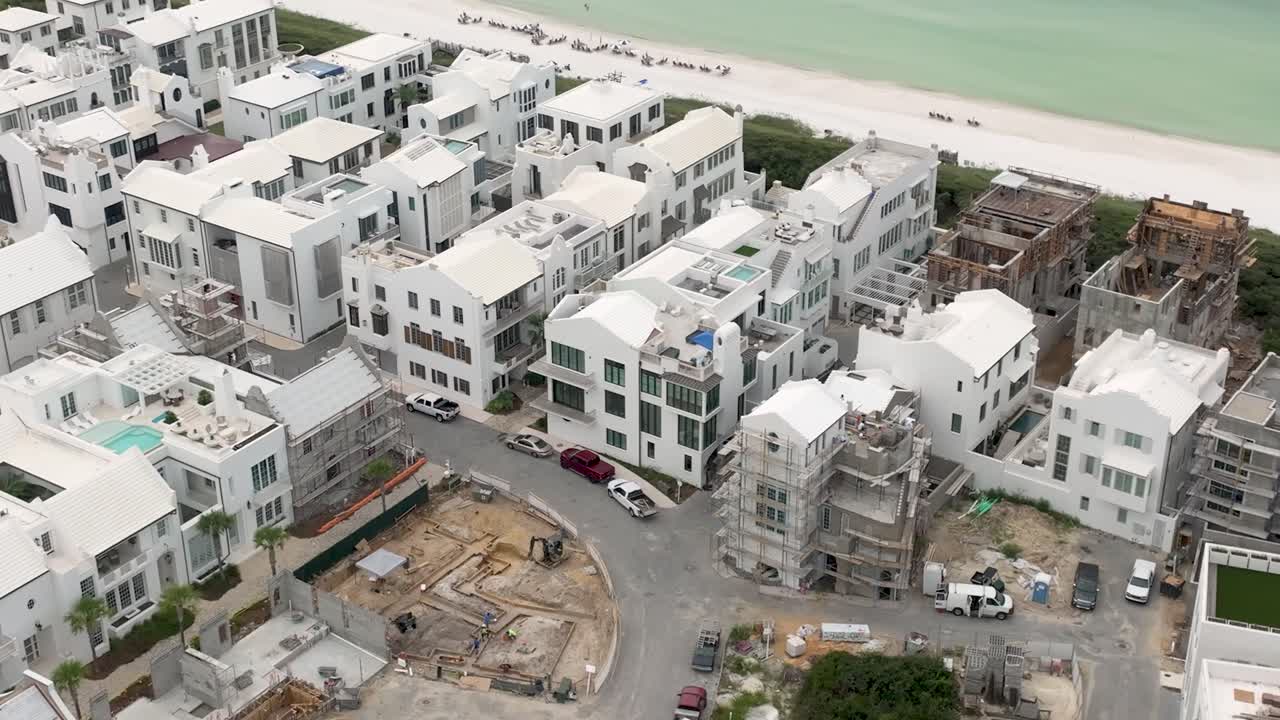 Alys Beach Florida'da okyanus kenarında yapım aşamasında olan beyaz evlerin sağa doğru dönüşü.