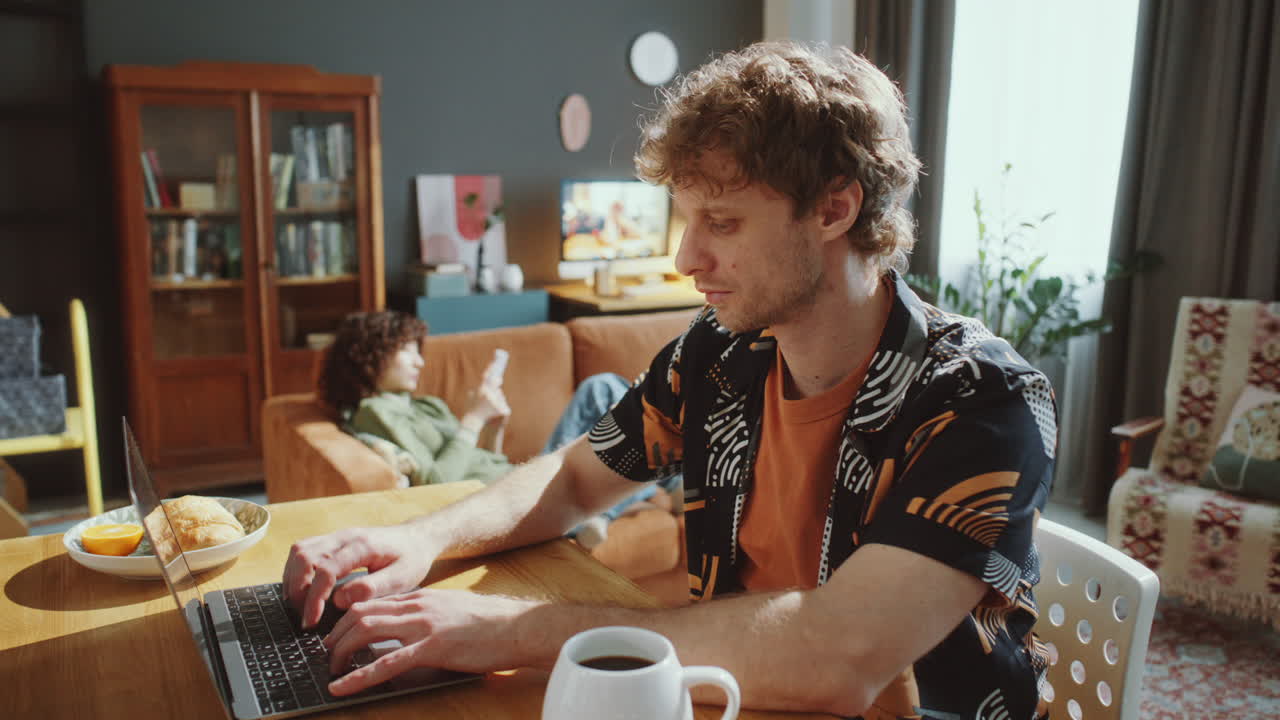 Focused Man Typing on Laptop as Working Online at Home