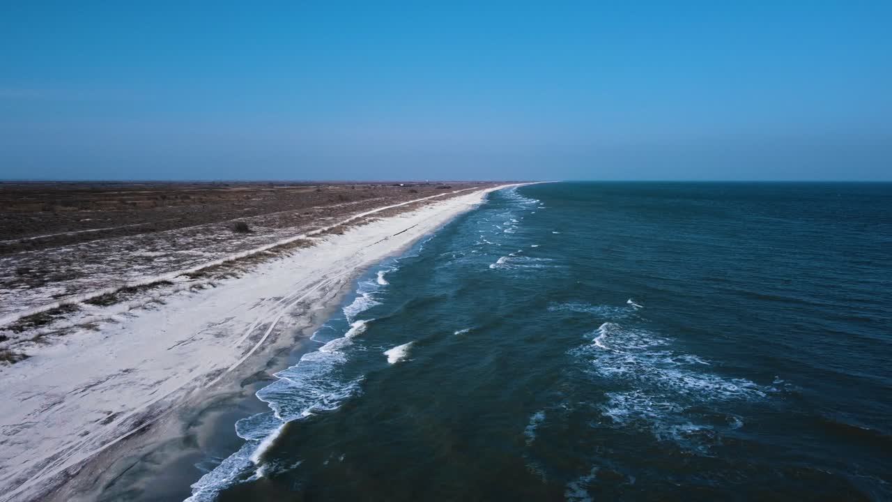 la orilla del mar desde arriba con olas rompiendo en la playa