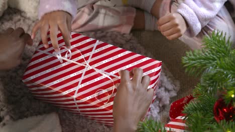 draufsicht des kindes beim auspacken des geschenks