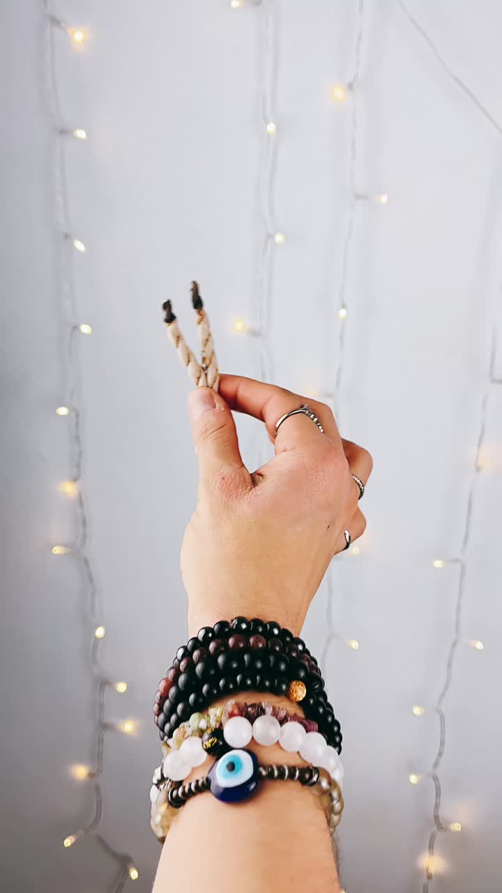 Hand Holding Burning Incense Sticks