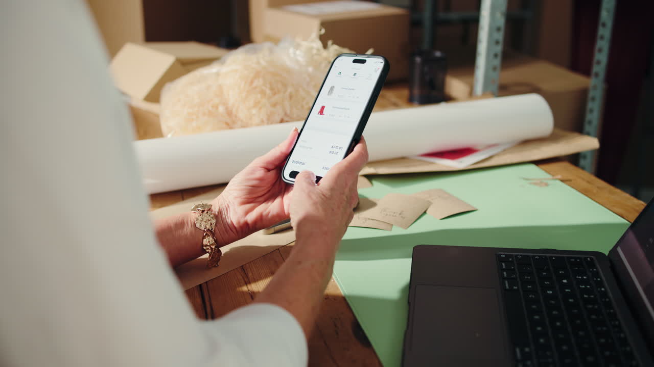 Mani che usano uno smartphone per acquisti online e pagamenti.
