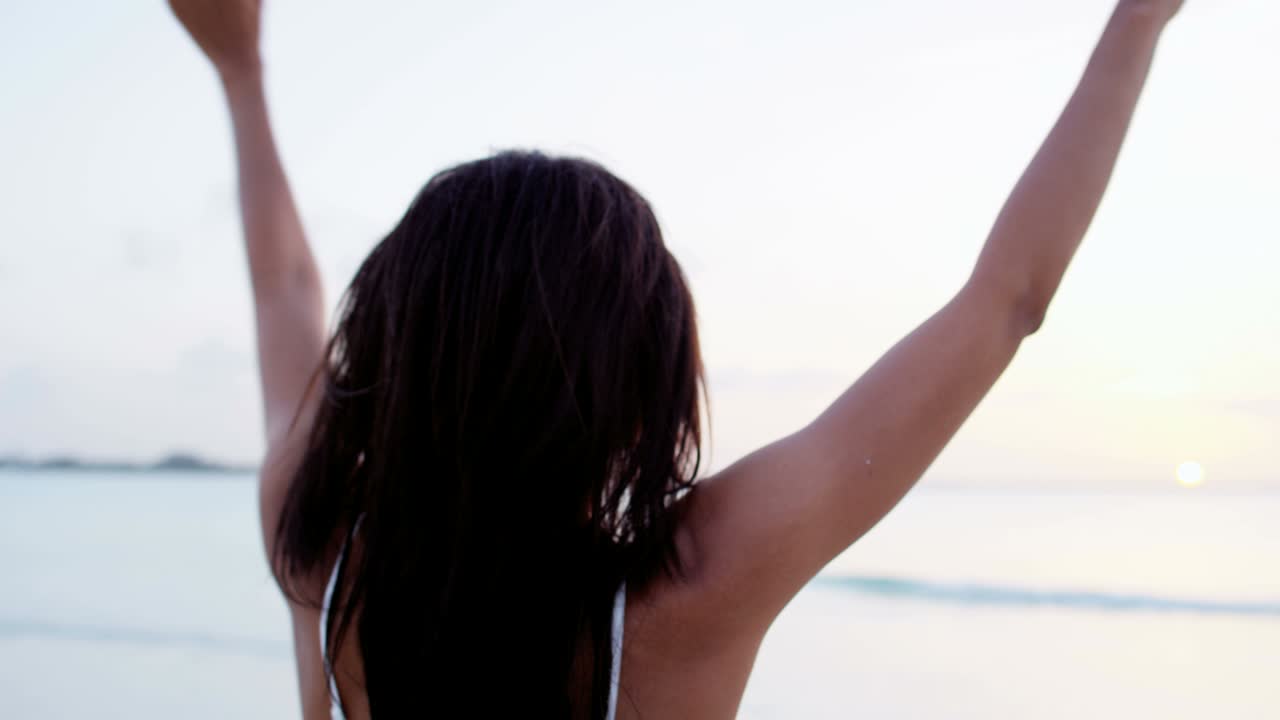 una chica afroamericana sonriente tomando una selfie en la playa